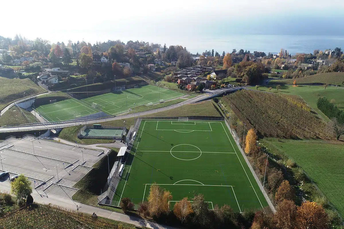 Vue aérienne de terrains de football intégrés dans le paysage communal